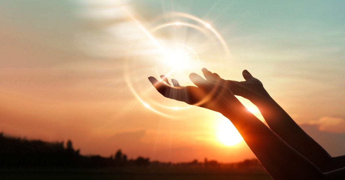 Woman-hands-praying-for-blessing-from-god-on-sunset-background