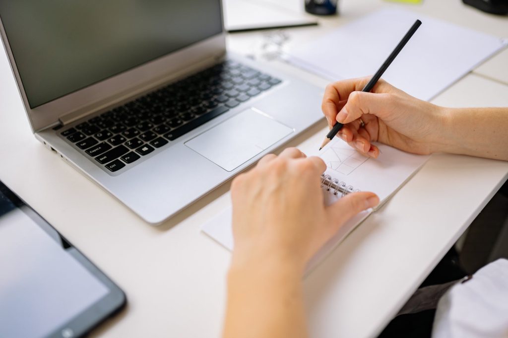 a person sketching on a notebook