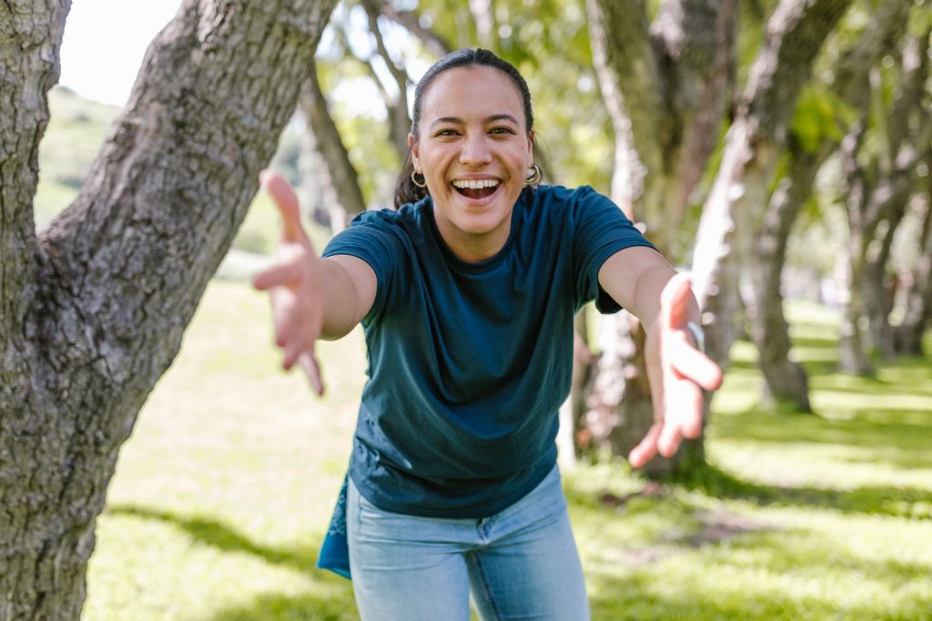 smiling woman in blue crew neck t shirt with open arms