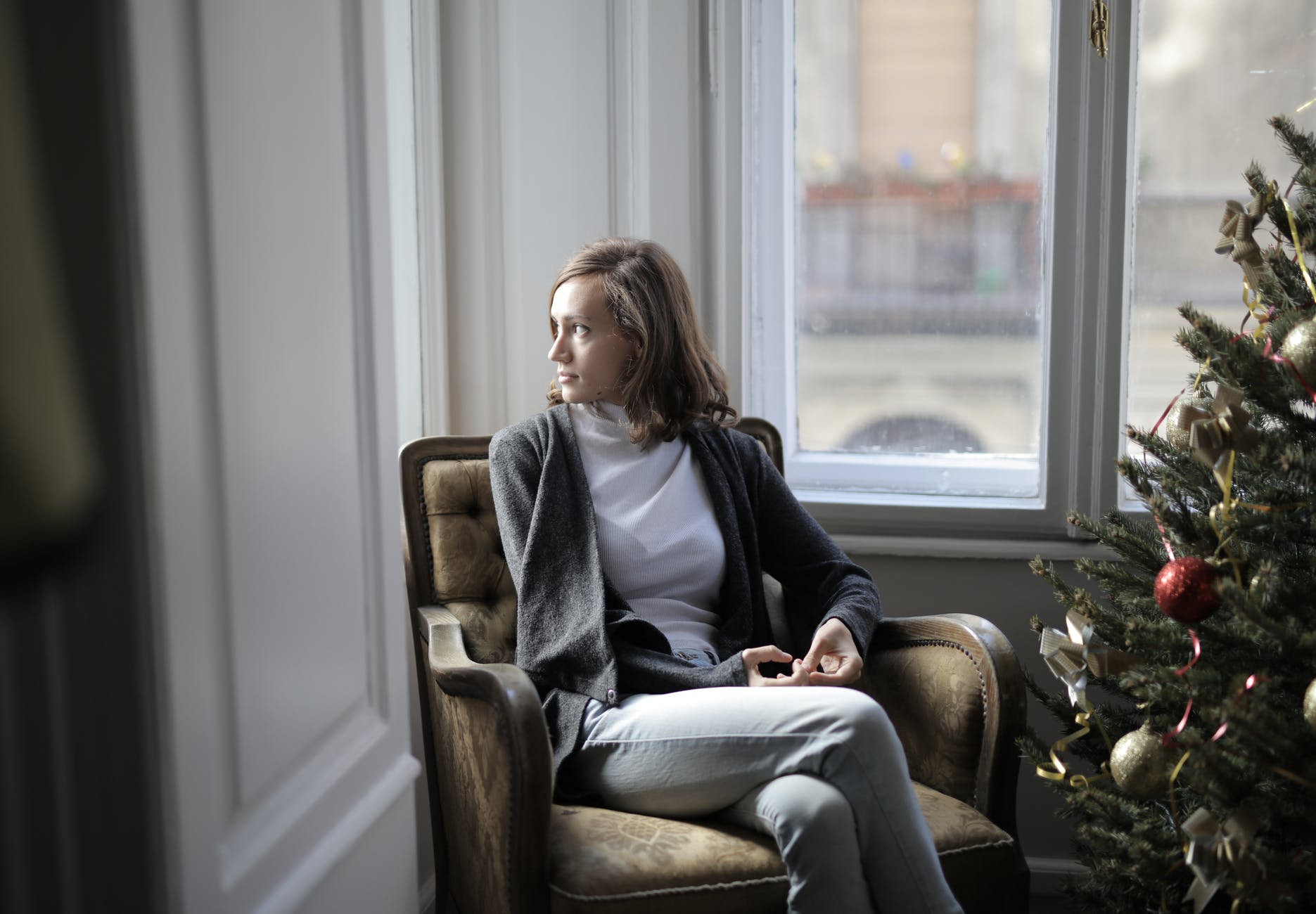 woman in black jacket sitting on brown armchair